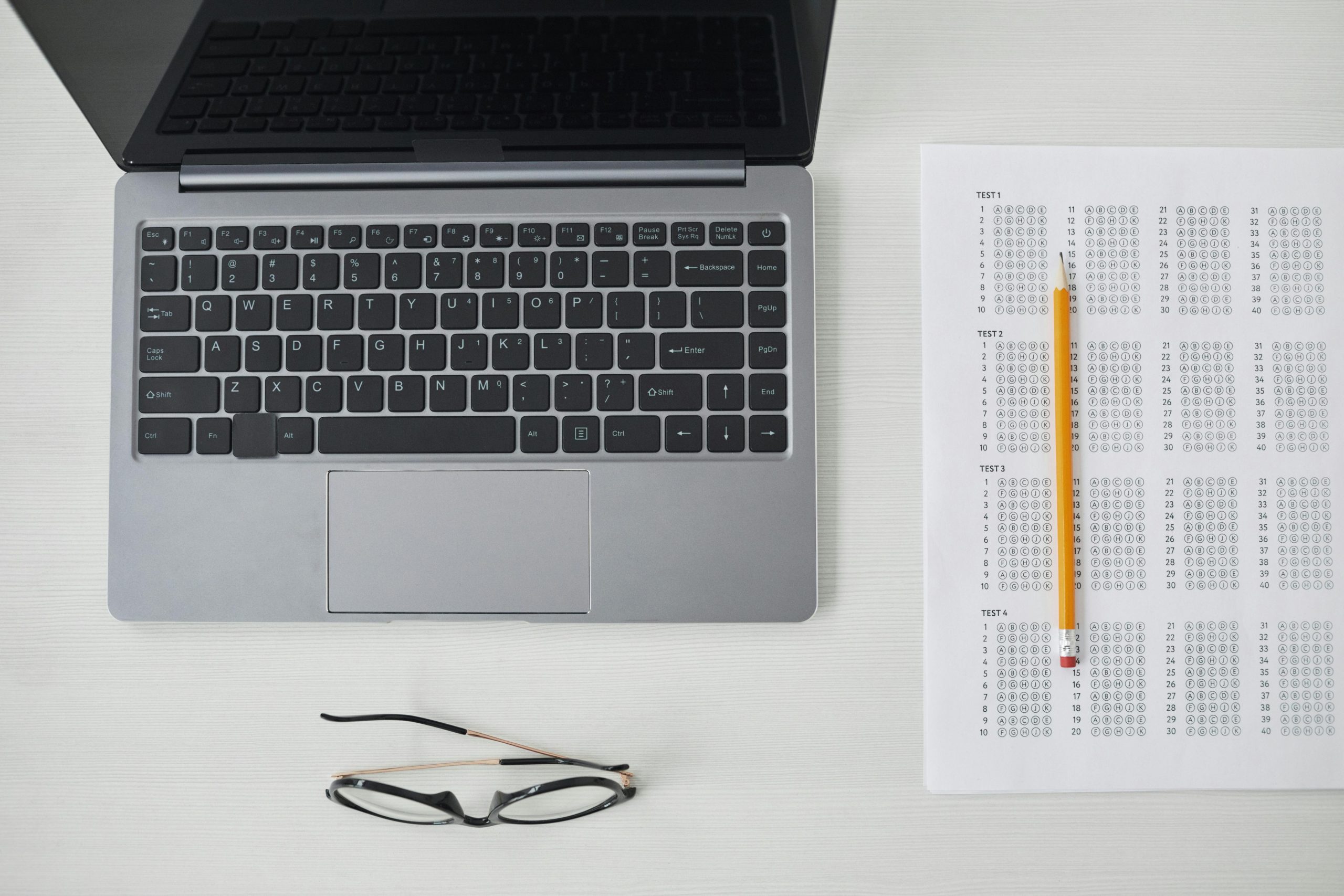 A Top View of Laptop and Test Paper on the Table